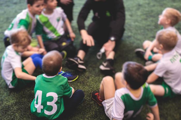 Football coach talking to children